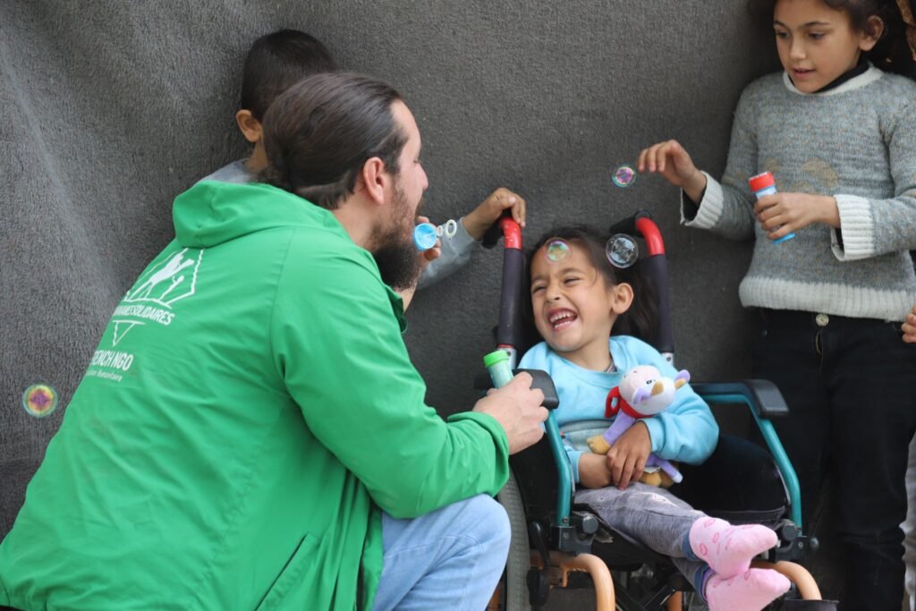 Petite fille syrienne en fauteuil roulant qui sourit