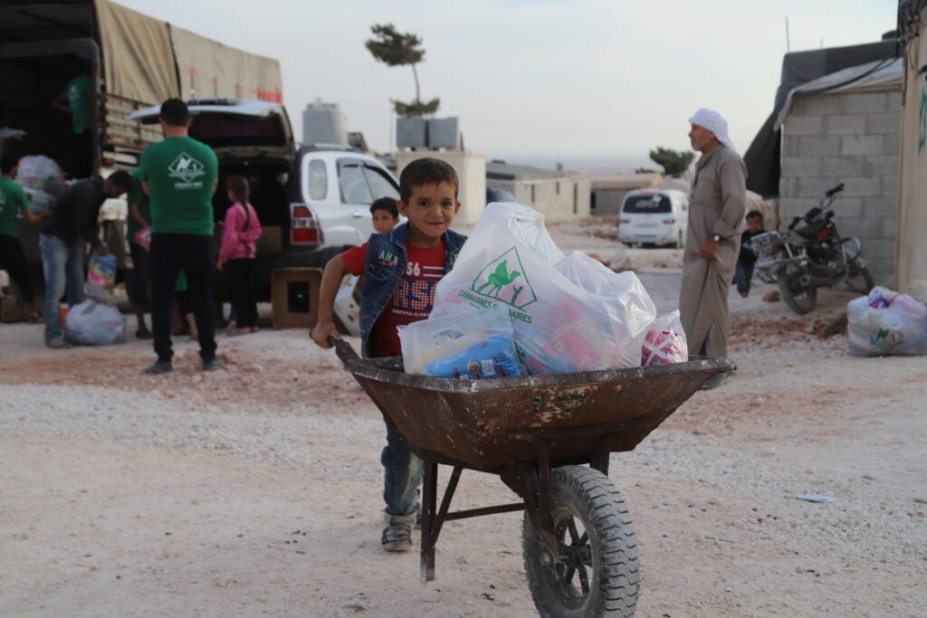 Petit garçon syrien qui tire l'aide humanitaire dans une brouette