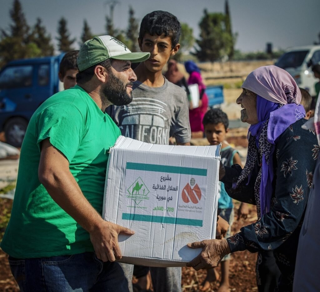 Notre humanitaire qui donne un colis alimentaire à une femme syrienne